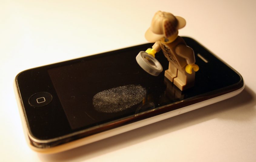 Sherlock Holmes en Lego étudie lune empreinte digitale sur l'écran d'un iPhone.